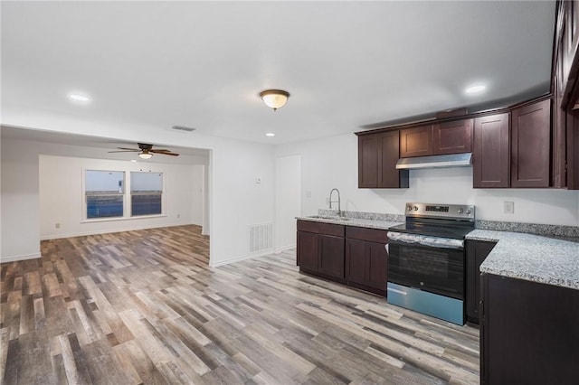 kitchen with dark brown cabinetry, sink, stainless steel electric range, and light stone countertops