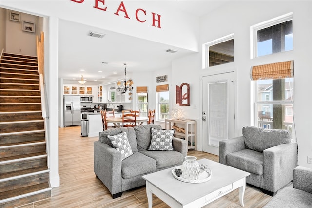 living room with a chandelier and light wood-type flooring