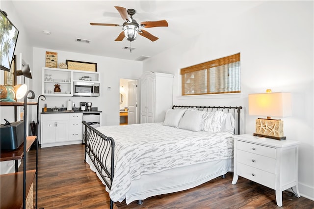 bedroom featuring dark wood-type flooring, sink, ceiling fan, and ensuite bathroom