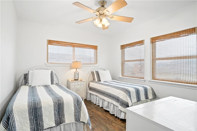 bedroom with ceiling fan, dark hardwood / wood-style floors, and multiple windows