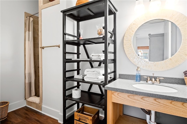 bathroom with curtained shower, wood-type flooring, and sink