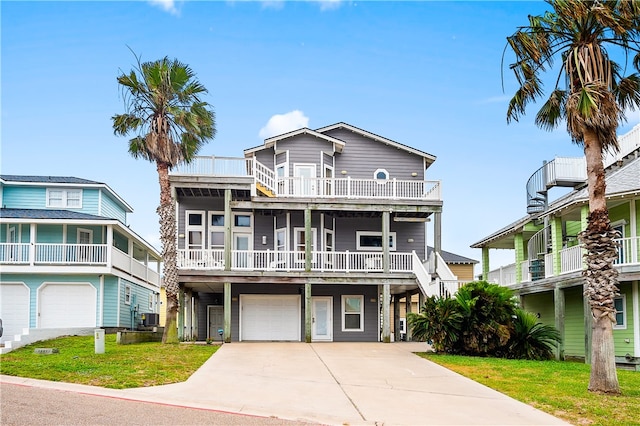 coastal home with a garage, a front yard, and a balcony