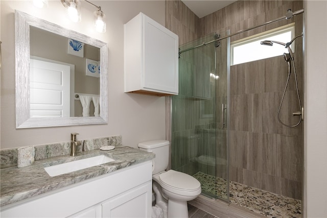 bathroom featuring vanity, toilet, and an enclosed shower