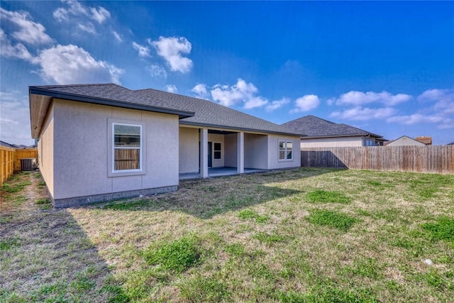 rear view of house with a yard and central AC