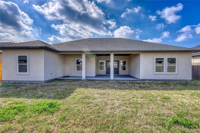 rear view of house with a yard and a patio