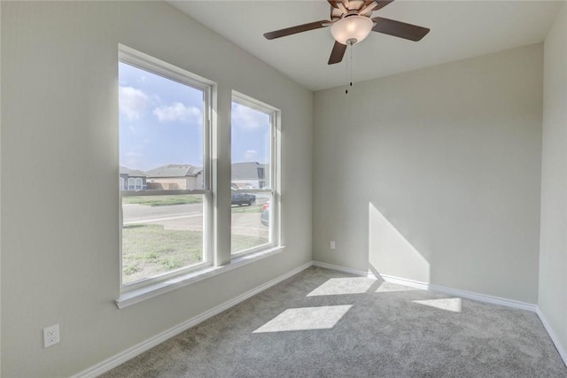 carpeted spare room with ceiling fan