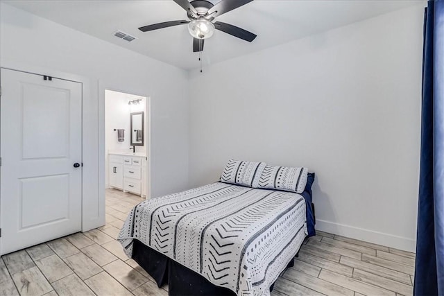 bedroom featuring light wood-type flooring, ceiling fan, and ensuite bath