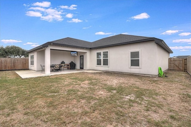 rear view of house with a yard and a patio