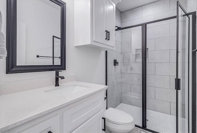 bathroom featuring toilet, an enclosed shower, and vanity