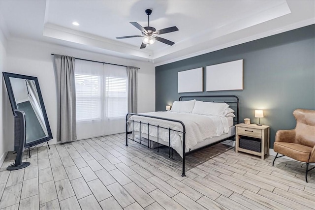 bedroom with ceiling fan, crown molding, and a tray ceiling