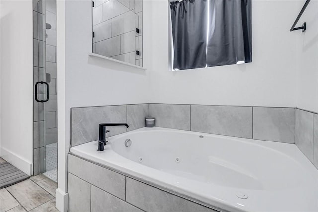 bathroom featuring shower with separate bathtub