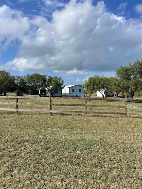 view of yard featuring a rural view and fence