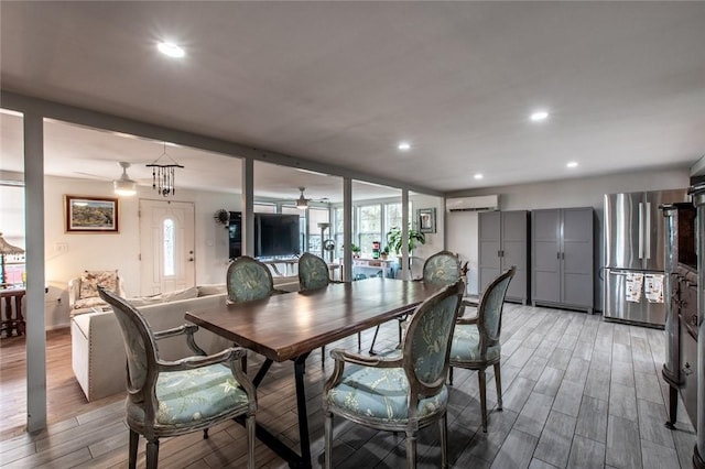 dining room with light wood-style flooring, a ceiling fan, an AC wall unit, and recessed lighting