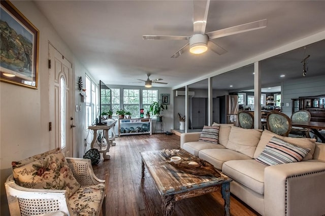 living area featuring a ceiling fan, wood-type flooring, and a wall mounted air conditioner