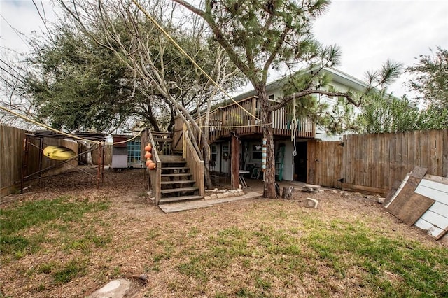 back of house with a fenced backyard, stairway, and a deck