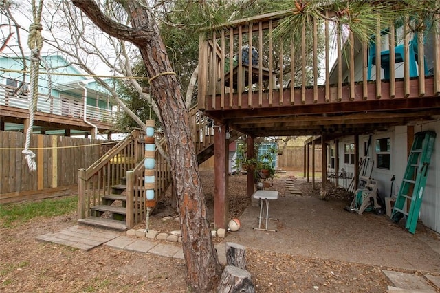 exterior space featuring fence, a wooden deck, and stairs