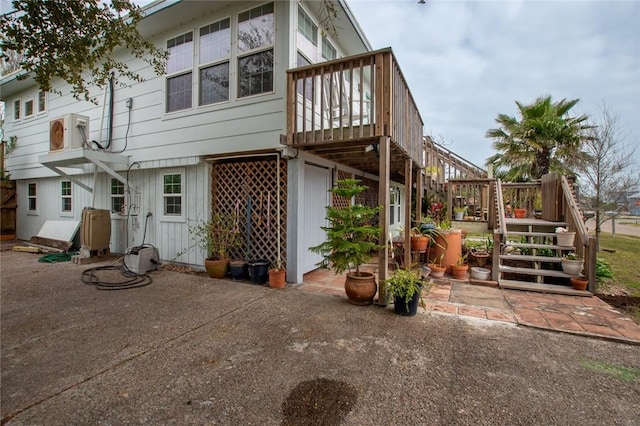 rear view of house with a patio area, stairs, and a deck