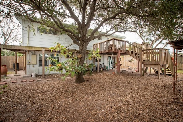 rear view of house featuring stairs, fence, and a wooden deck