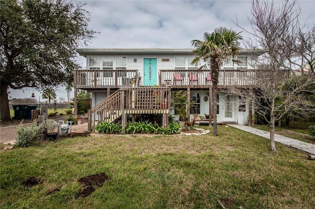 rear view of property featuring a lawn, a wooden deck, and stairs