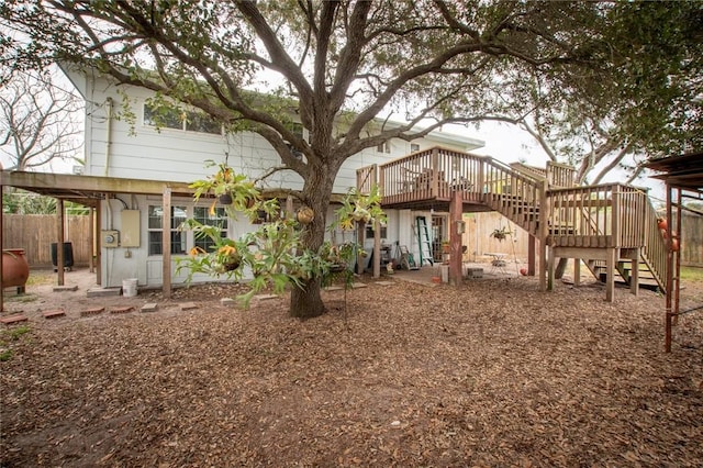 rear view of property with fence, stairway, and a deck