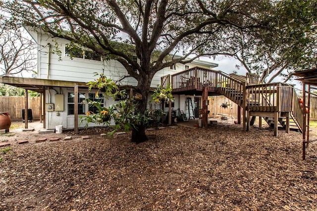 back of property with stairs, fence, and a wooden deck