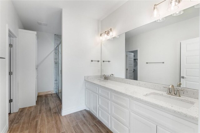 9409 Royal Oak Dr, Corpus Christi, TX 78410 - bathroom with double vanity, wood finished floors, a shower with door, and a spacious closet