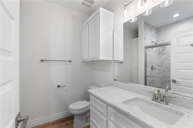 bathroom featuring vanity, an enclosed shower, and toilet