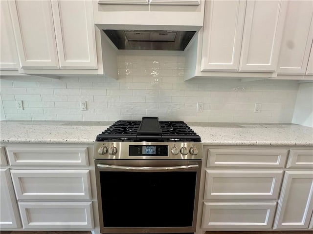 9409 Royal Oak Dr, Corpus Christi, TX 78410 - kitchen with stainless steel gas range oven, white cabinets, backsplash, and exhaust hood