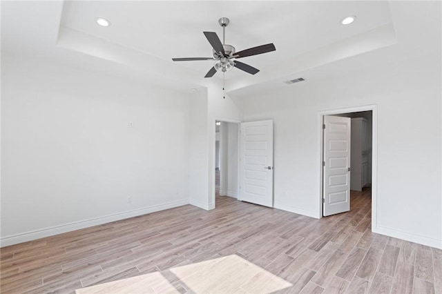 9409 Royal Oak Dr, Corpus Christi, TX 78410 - unfurnished bedroom with light wood-style flooring, recessed lighting, a tray ceiling, and ceiling fan