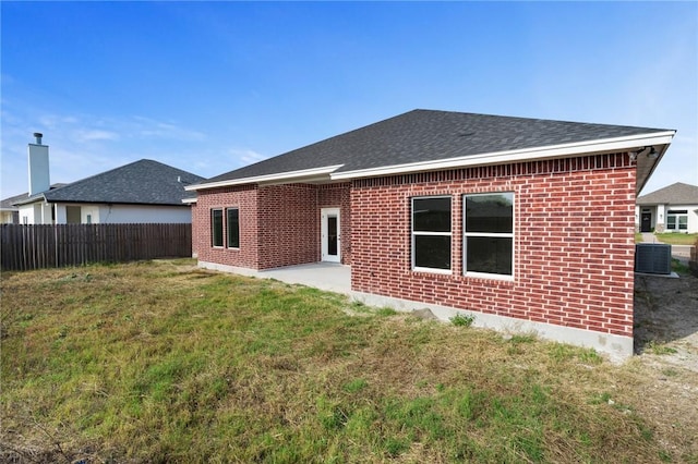 rear view of house with a lawn, a patio area, and central air condition unit