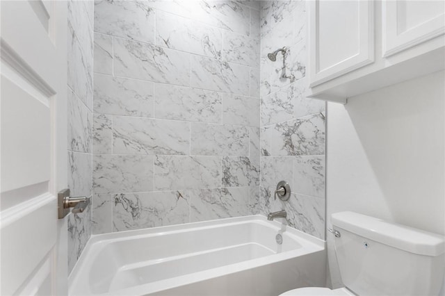 bathroom featuring toilet and tiled shower / bath