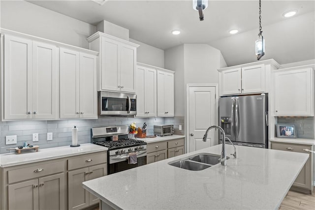 kitchen with sink, white cabinetry, stainless steel appliances, and tasteful backsplash