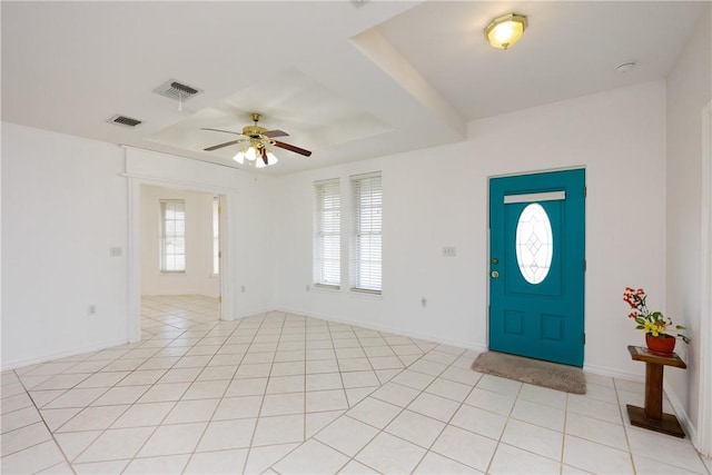 foyer with light tile patterned floors, a ceiling fan, visible vents, and baseboards