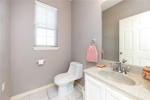 bathroom featuring toilet, tile patterned flooring, baseboards, and vanity