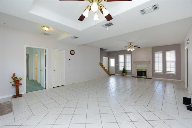 8101 Mt Zion, Corpus Christi, TX 78413 - unfurnished living room featuring ceiling fan, a brick fireplace, stairway, and light tile patterned floors