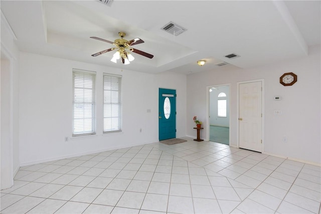 foyer with visible vents, a raised ceiling, a ceiling fan, and light tile patterned flooring