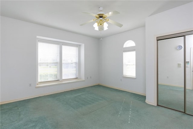 empty room with carpet flooring, ceiling fan, and baseboards