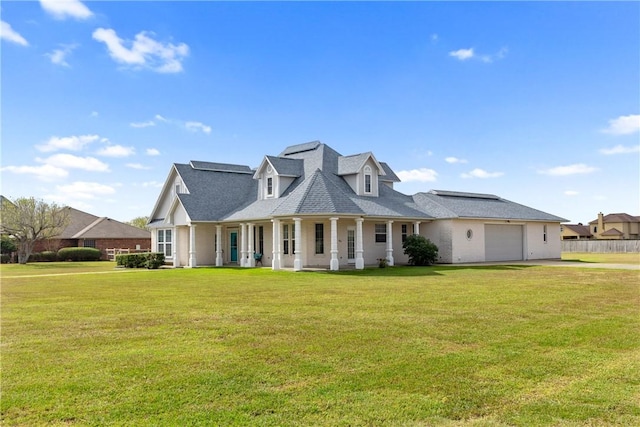 view of front of house featuring covered porch, roof with shingles, an attached garage, and a front lawn