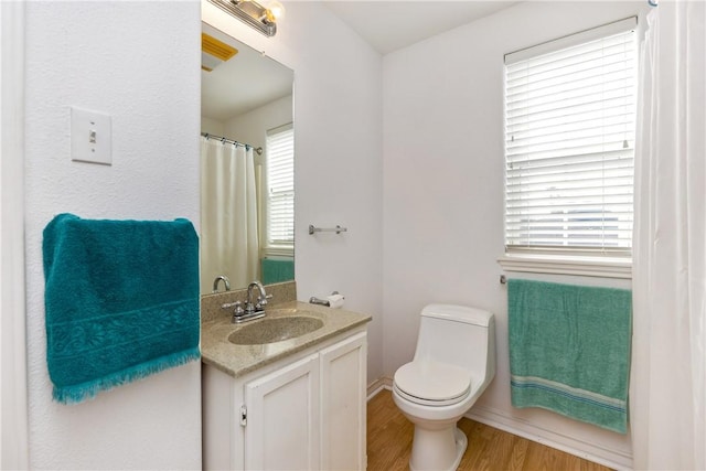 full bath featuring toilet, wood finished floors, and vanity