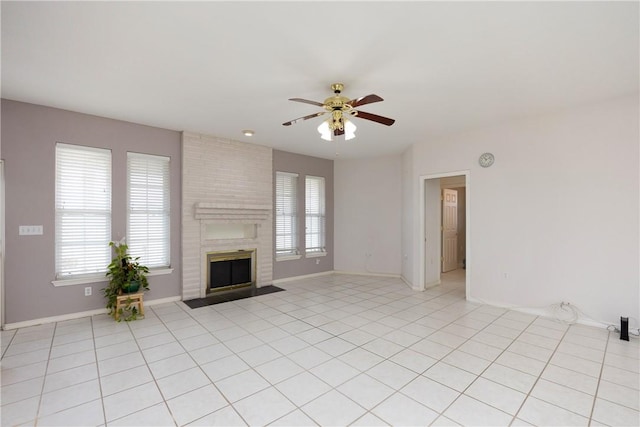 unfurnished living room featuring a healthy amount of sunlight, light tile patterned floors, a fireplace, and a ceiling fan