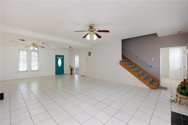 unfurnished living room featuring light tile patterned floors, visible vents, stairway, a ceiling fan, and baseboards