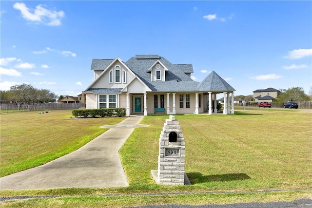 view of front facade featuring a shingled roof and a front lawn