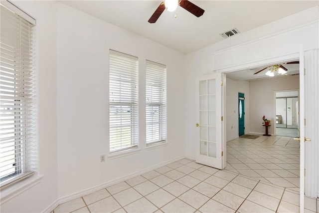 unfurnished room featuring light tile patterned floors, ceiling fan, visible vents, and baseboards