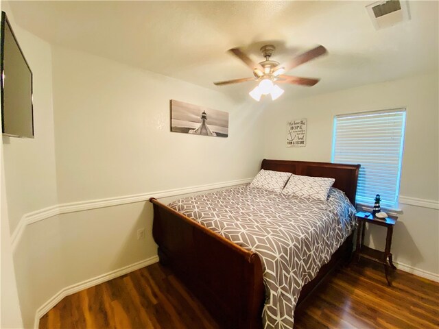 bedroom with dark hardwood / wood-style flooring and ceiling fan