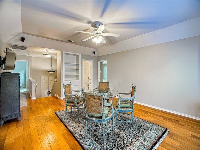 dining area with light wood-style flooring, built in shelves, visible vents, and baseboards