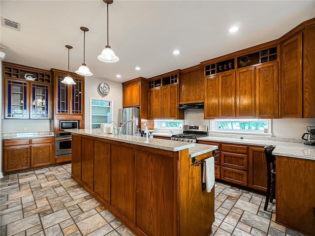 kitchen with a center island with sink, visible vents, stainless steel appliances, stone tile flooring, and open shelves