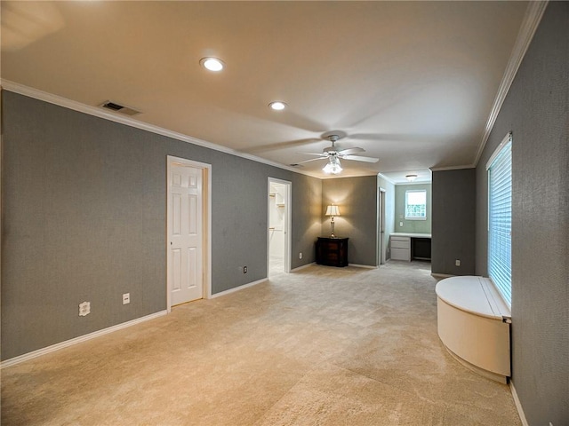 interior space with light carpet, visible vents, baseboards, a ceiling fan, and ornamental molding