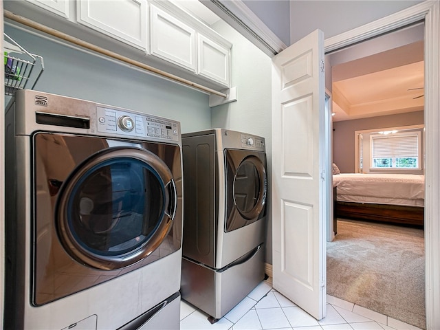 laundry room with washer and dryer, light carpet, and light tile patterned floors