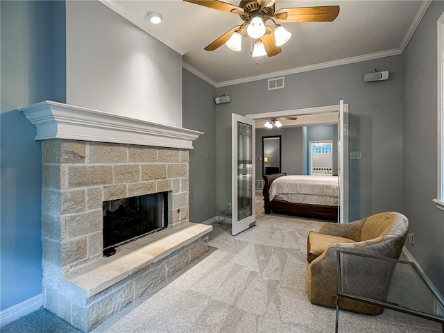 carpeted bedroom featuring a stone fireplace, a ceiling fan, visible vents, baseboards, and ornamental molding