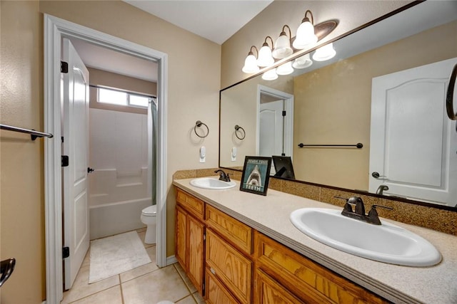 full bath with toilet, double vanity, a sink, and tile patterned floors